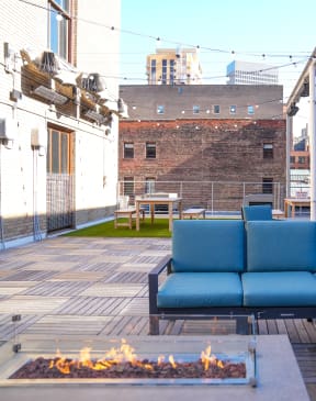 a patio with blue couches and a fire pit at East 4th Street, Cleveland, 44115