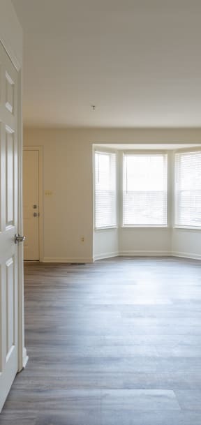 an empty living room with white walls and a window at Carlson Woods Townhomes, Baltimore, MD, 21244