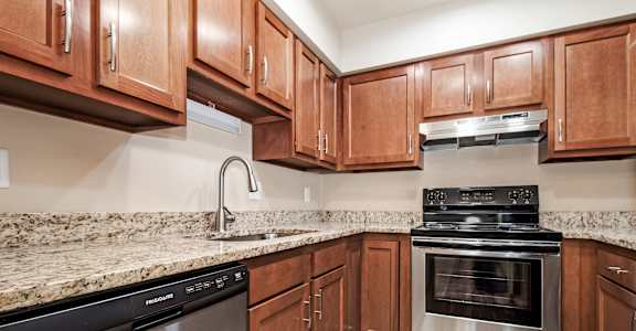 A kitchen with wooden cabinets and a granite countertop.