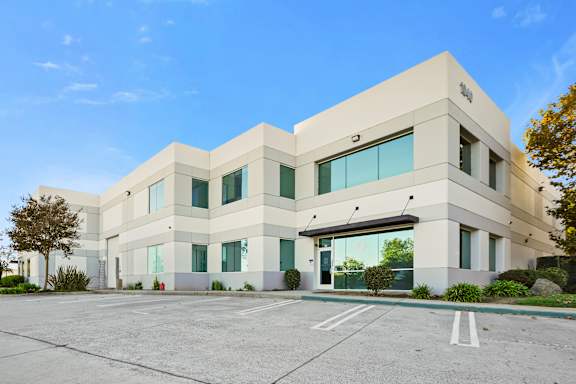 A modern building with a parking lot in front.