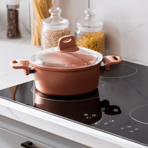 a brown pot on a stove with a lid on it