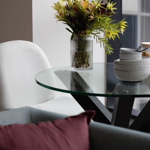 a glass table with a vase with flowers on it