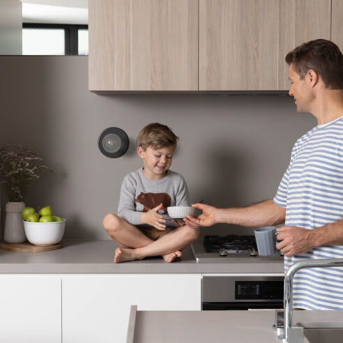 a man and a boy sitting on a counter in a kitchen