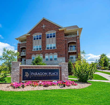 A brick building with a sign that says Paragon Place in front of it.