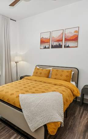 A bedroom with a large bed and a ceiling fan.