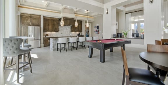 a clubhouse with a pool table and a kitchen with a bar
