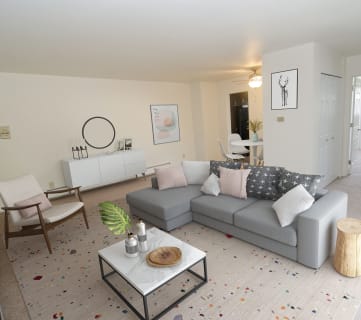 a living room with a grey couch and a white coffee table
