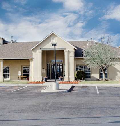A building with a parking lot in front of it at Arrowhead Ridge Apartments, Rio Rancho, NM, 87124