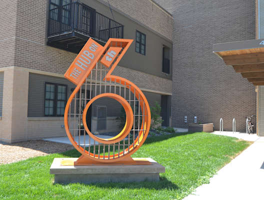 a statue of the number six in front of an apartment building