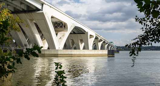 A white bridge with a unique design spans over a body of water.