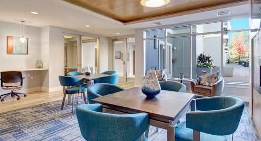 A conference room with a long table and blue chairs.