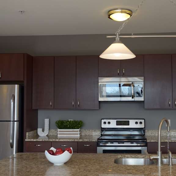 A kitchen with a stove top oven and a refrigerator. at Cornerstone & Ravenna* Apartments, Shorewood, Wisconsin