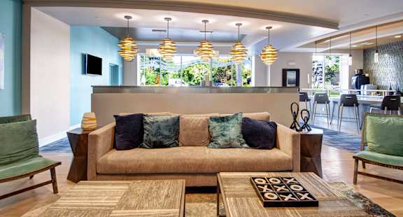 A living room with a couch, chairs, and a rug.