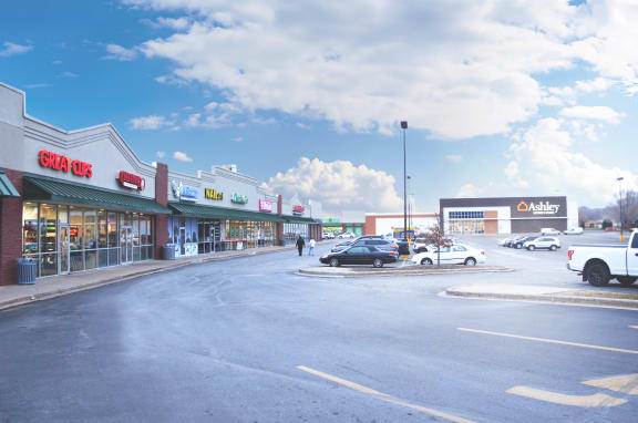 the parking lot of a shopping mall with cars parked in front of it