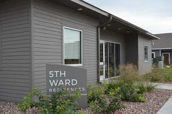 the front of a building with a sign for 5th ward apartments