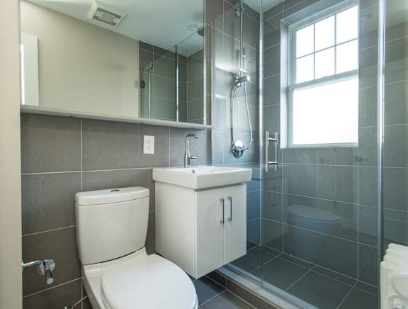 A white toilet and sink in a modern bathroom.
