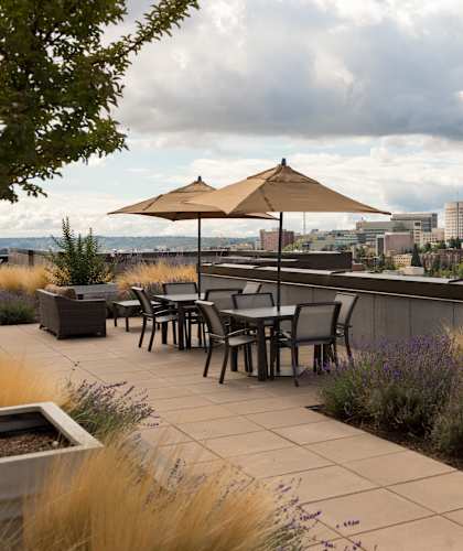 A patio with a table and chairs overlooking a city skyline.
