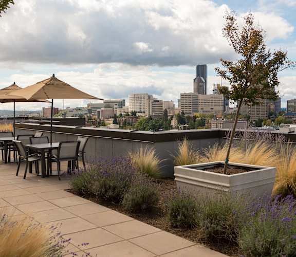 A patio with a table and chairs overlooking a city skyline.