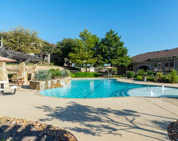 A swimming pool with a fountain in the middle of it.