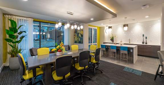 a conference room with a table and chairs and a kitchen