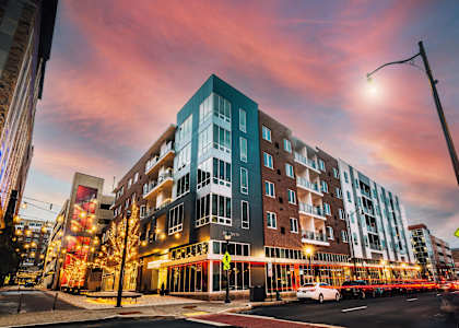 a new apartment building on a city street at sunset