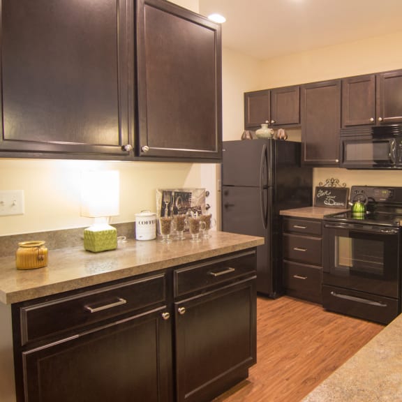a kitchen with black appliances and granite counter tops  at Grove City Summit, Grove City, OH