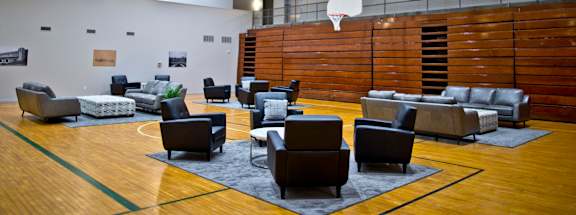 A basketball court with a hoop and a variety of seating.