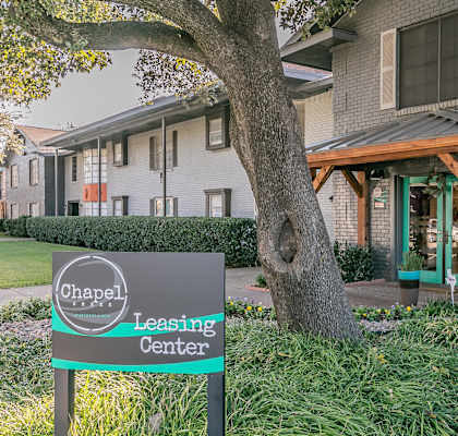 A sign for the Chapel Leasing Center stands in front of a building.