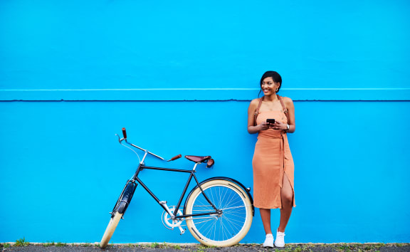 a woman standing next to a bike looking at her phone