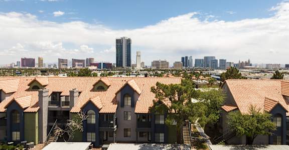 A row of houses with a city skyline in the background.