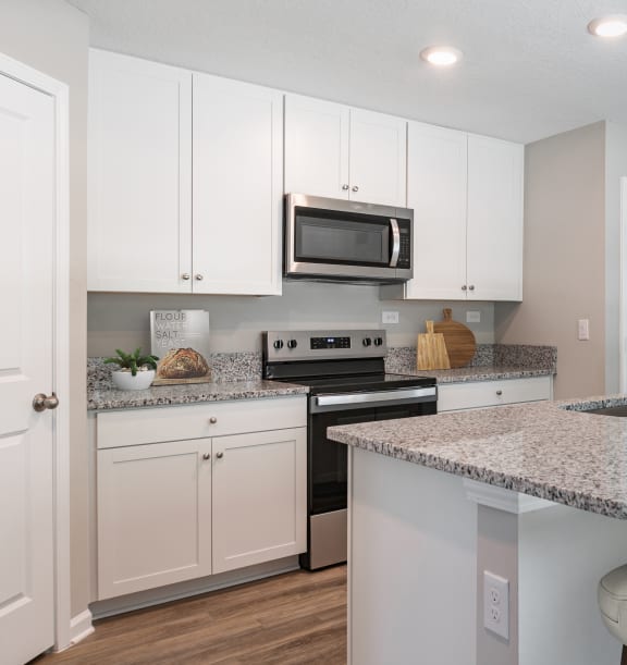 a kitchen with white cabinets and a granite counter top