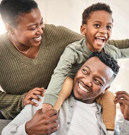 A man is giving a piggyback ride to a child on his shoulders.