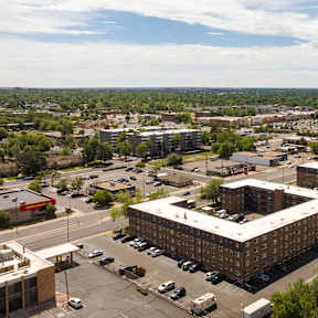 A large building complex with a parking lot in front.
