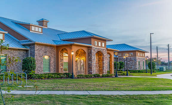 A house with a blue roof and a green lawn in front.