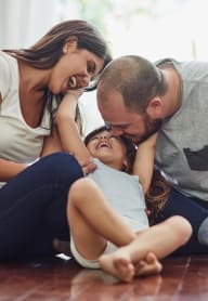 a man and woman playing with a child on the floor