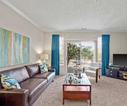 a living room with a leather couch and a coffee table in front of a flat screen tv