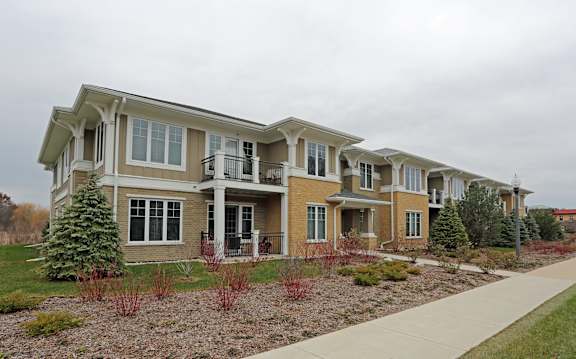 A row of houses with a sidewalk in front.