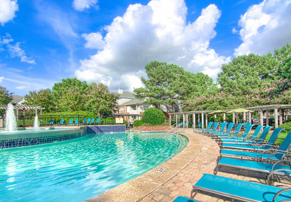 Enclave at Wolfchase Apartments in Cordova Tennessee photo of a resort style pool with chaise lounge chairs and a fountain