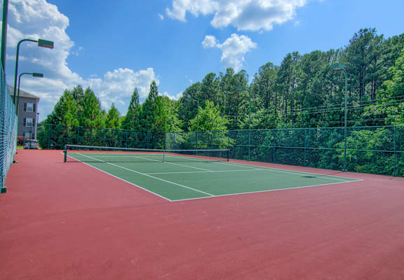 a tennis court with trees in the background