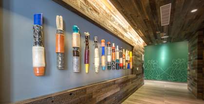 a wall of colorful bottles on a blue wall in a lobby