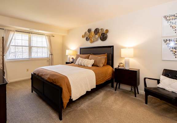 A bedroom with a large bed and a chair.