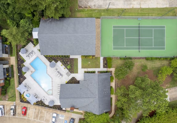 arial view of a house with a tennis court and pool