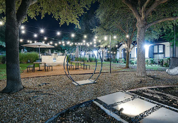 a night view of a park with trees and lights