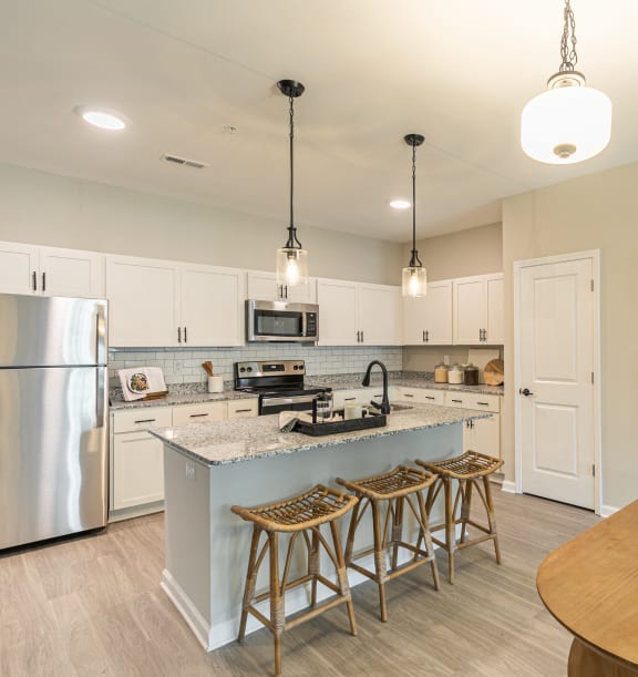 an open kitchen and dining area with a large island and stainless steel appliances