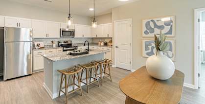 an open kitchen and dining area with a large island and stainless steel appliances