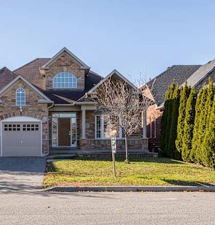 A house with a brick facade and a large front yard.