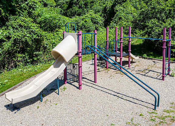 A playground with a slide and monkey bars.
