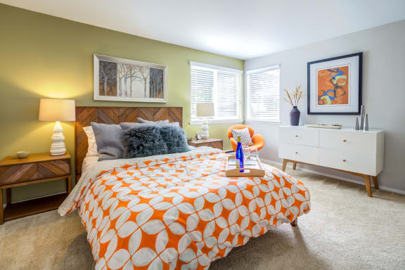 a bedroom with a bed and two windows