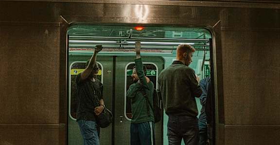 a group of people standing on a subway train