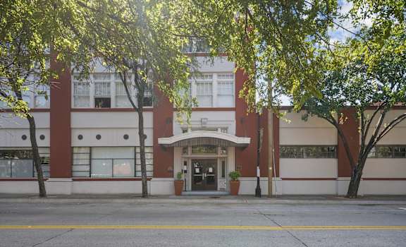the front of a building with trees in front of it